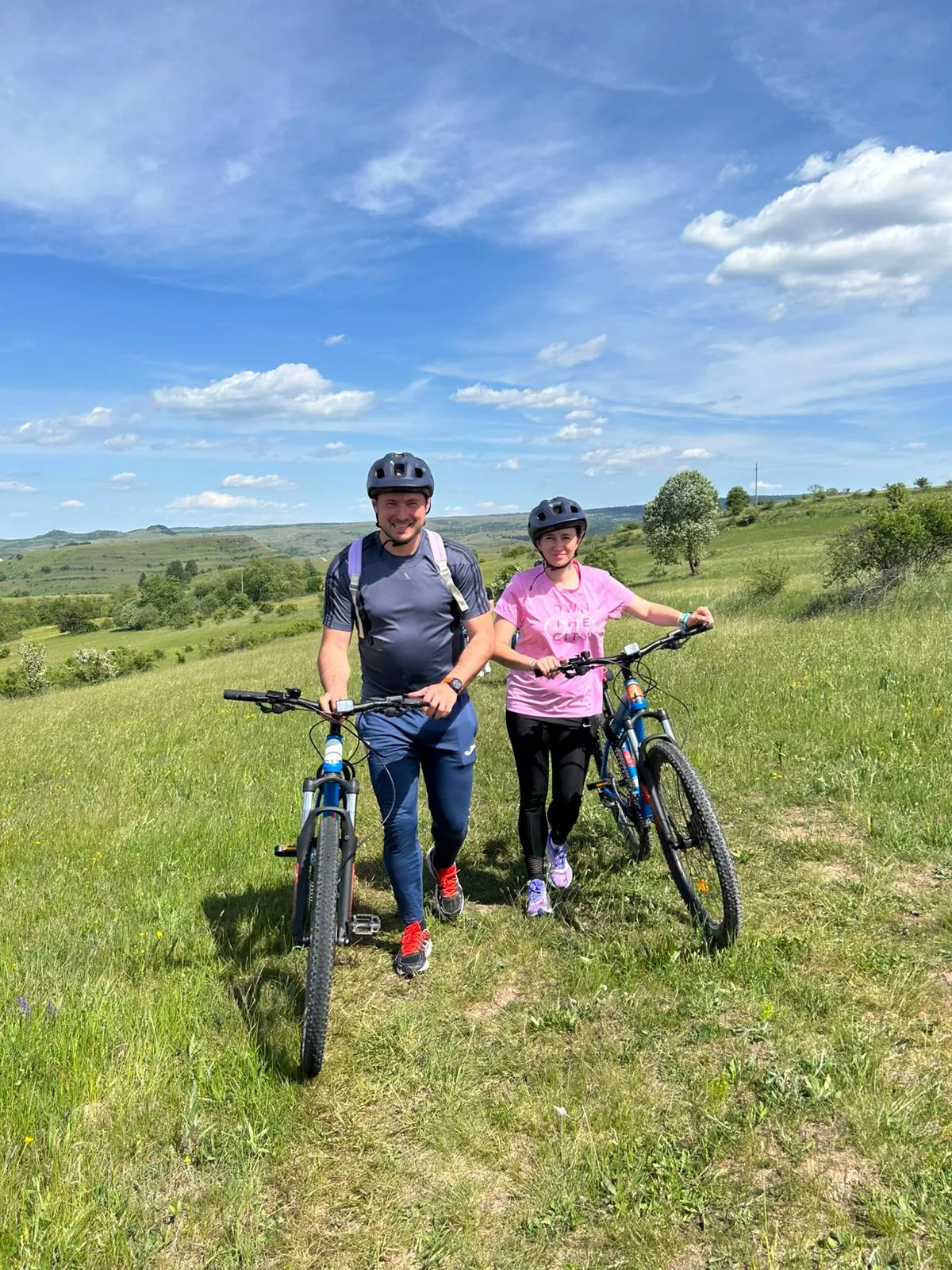A couple with bikes in a meadow